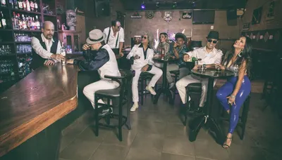 Cena de bar, a banda nas mesas altas ao fundo