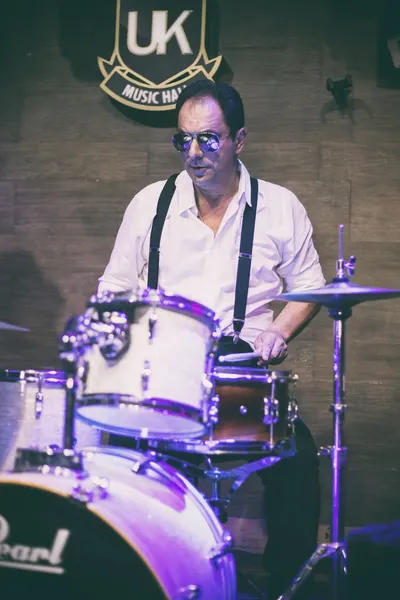 Close do baterista com óculos escuros