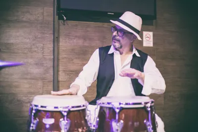 Close do percussionista de chapéu branco tocando conga