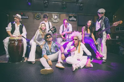 A banda completa posada no palco, outro ângulo da mesma sessão
