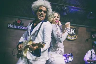 Guitarrista e vocalista dançando costas com costas no palco