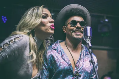 Close de dois vocalistas cantando lado a lado